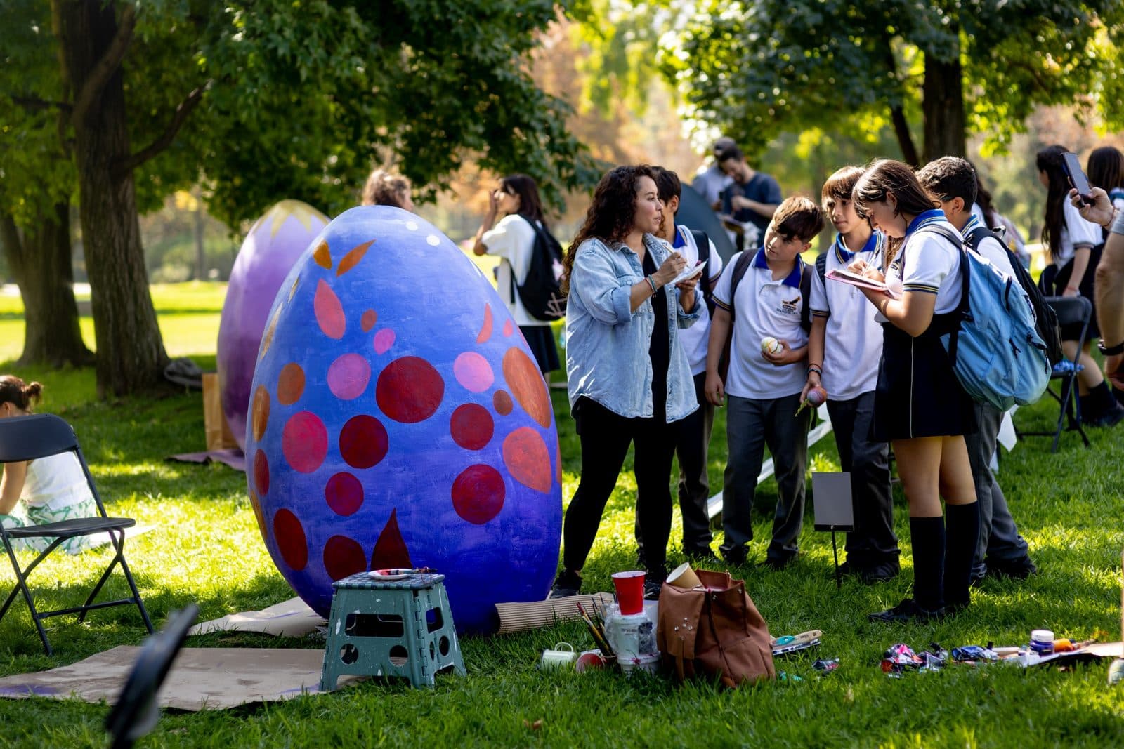 Huevo gigante pintado por estudiantes sobre el pasto