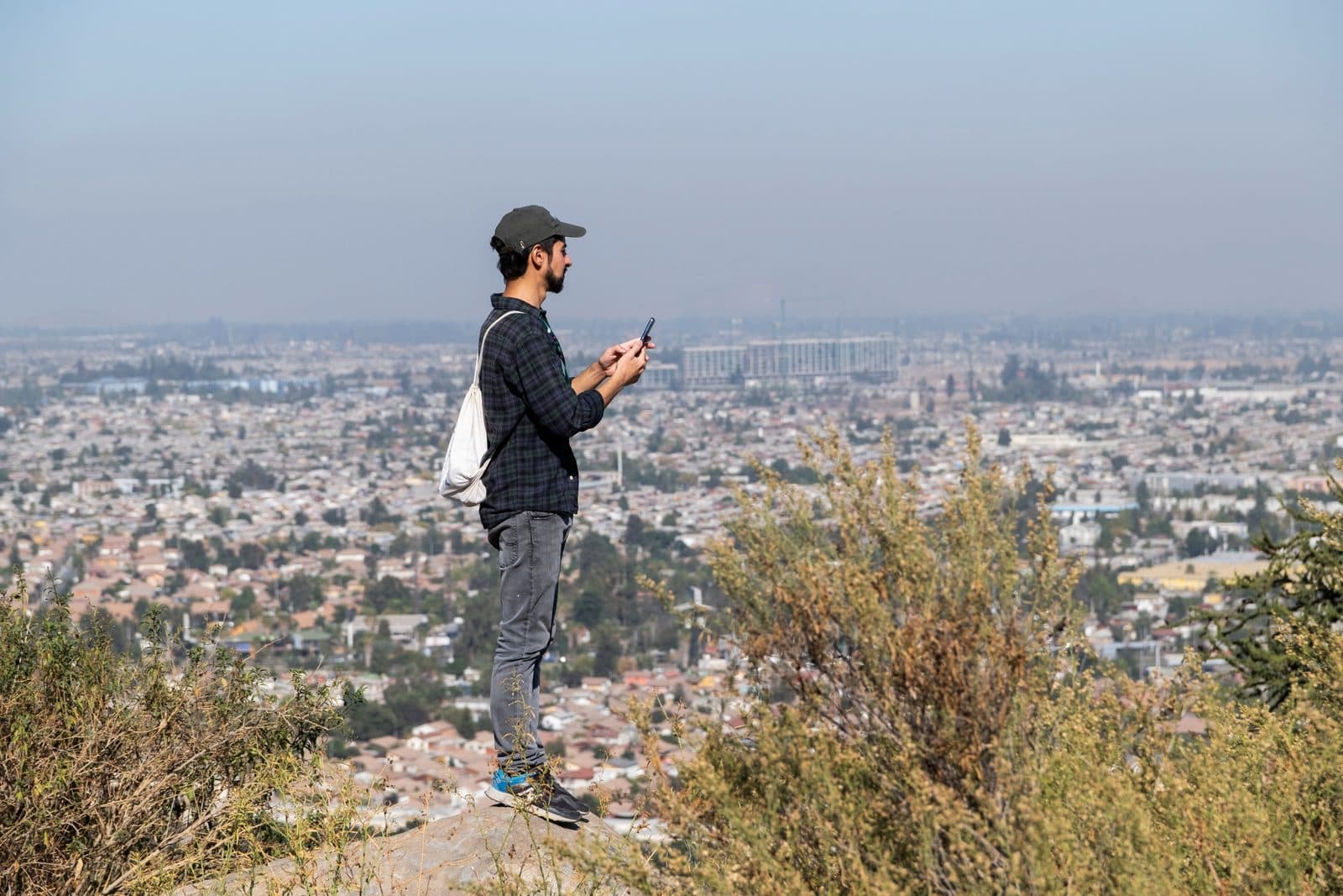 Visitante en un mirador del cerro Chequén con Santiago al fondo